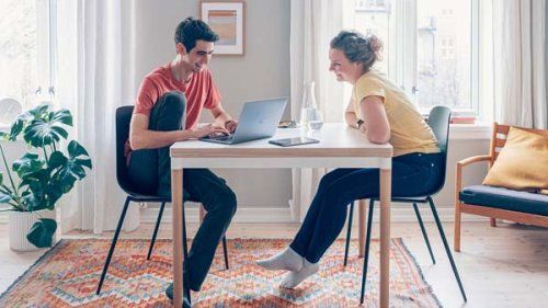 Ung mand og kvinde arbejder ved computeren i en stue