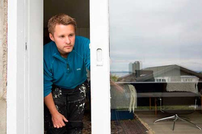 Tømrer der står og kigger ut gennem vinduet