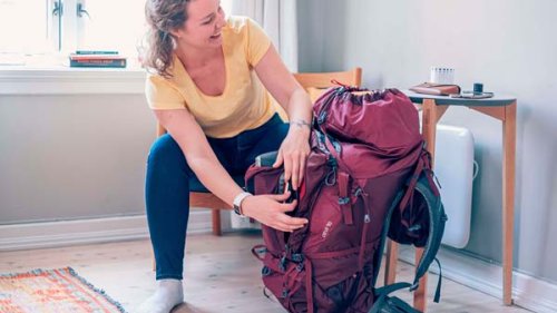 Ung kvinde pakker rygsæk til længere rejse måske til Asien, Australien eller Sydamerika