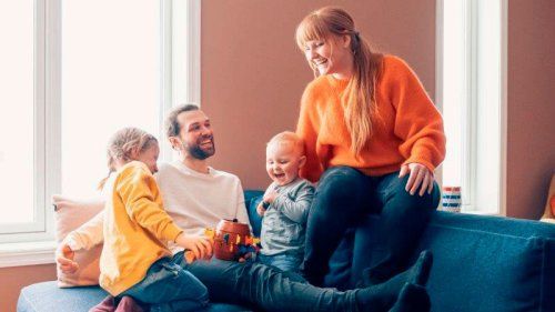 Familie i sofa der smiler, forældre og børn