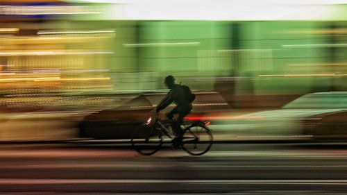 Cyklist cykler i mørket med lyset på sin cykel tændt