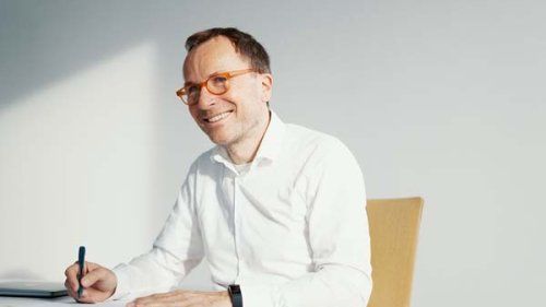 Mand i hvid skjorte der skriver