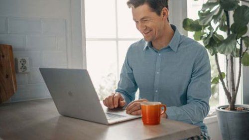 Mand med computer på hjemmekontor