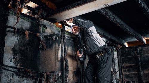 Taksator inspicerer nedbrændt bygning
