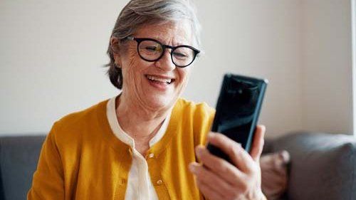 Kvinde taler i telefon over facetime smilende