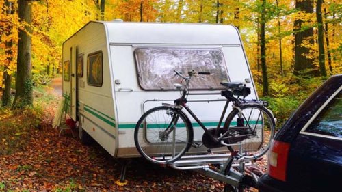 Campingvogn med cykel på i skoven